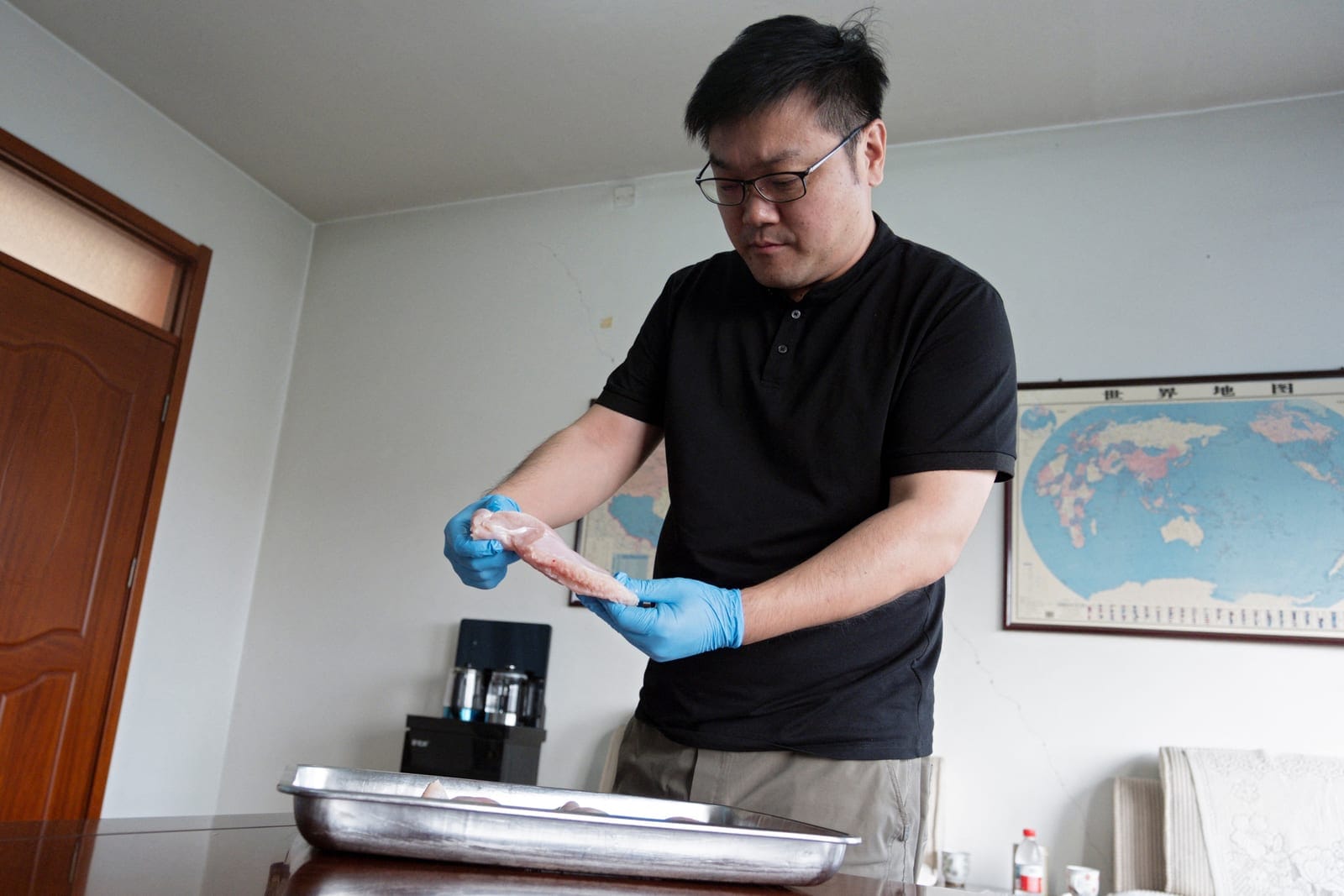 Dang Yangyang, general manager of poultry company Wintop Food Group, inspects chicken breast meat as he speaks to Reuters at his office in Tengzhou, Shandong province, China August 24, 2026. REUTERS/Ella Cao