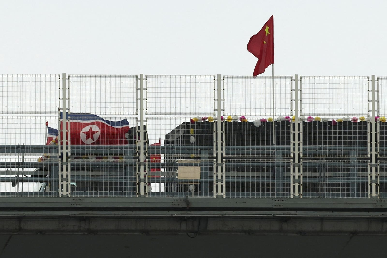 A truck adorned with North Korean flags enters the Chinese side of the newly opened New Yalu River Bridge, which connects China’s Dandong New Zone and North Korea’s Sinuiju, in Dandong, Liaoning province, China, October 15, 2026. REUTERS/Florence Lo