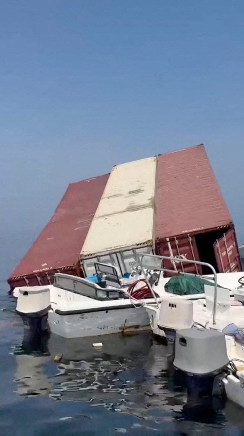 A container floats in the water a vessel sank near the Strait of Hormuz off the coast of Oman, in this still image obtained from a social media video, released October 14, 2026. Social Media/via REUTERS REUTERS/Social Media