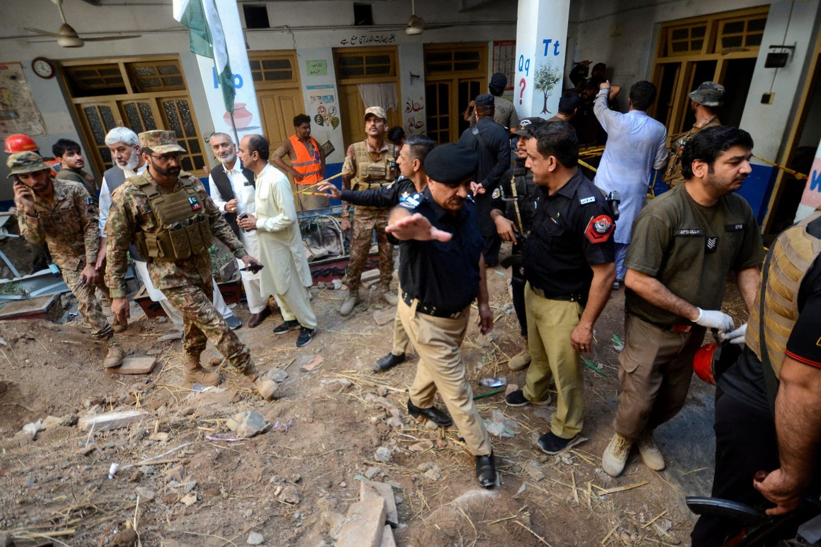 Police officers and military personnel gather as they are surveying the site of a school roof collapse at a hospital morgue in Peshawar, Pakistan, October 15, 2026. REUTERS REUTERS/Reuters