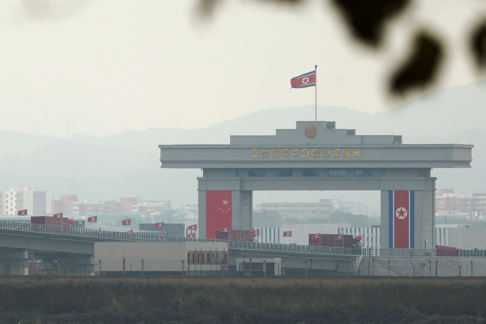 Trucks adorned with Chinese flags cross the newly opened New Yalu River Bridge to enter North Korea's Sinuiju from China's Dandong New Zone, as seen from Dandong, Liaoning province, China October 15, 2026. REUTERS/Florence Lo