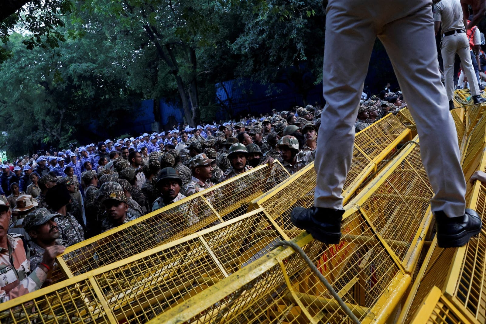 Police and security personnel stand guard behind barricades as opposition parties march to the Supreme Court to protest a controversial revision of voter lists that has sparked days of unrest, in New Delhi, India, October 12, 2026. REUTERS/Priyanshu 