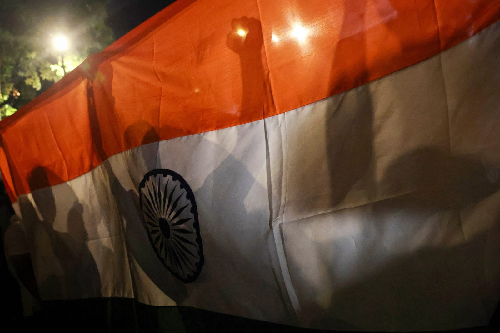Shadows of protesters are cast on the Indian flag as they chant slogans during a rally organised by the Cockroach Janta Party (CJP), demanding the resignation of India's Chief Election Commissioner Gyanesh Kumar, in New Delhi, India, October 16, 2026