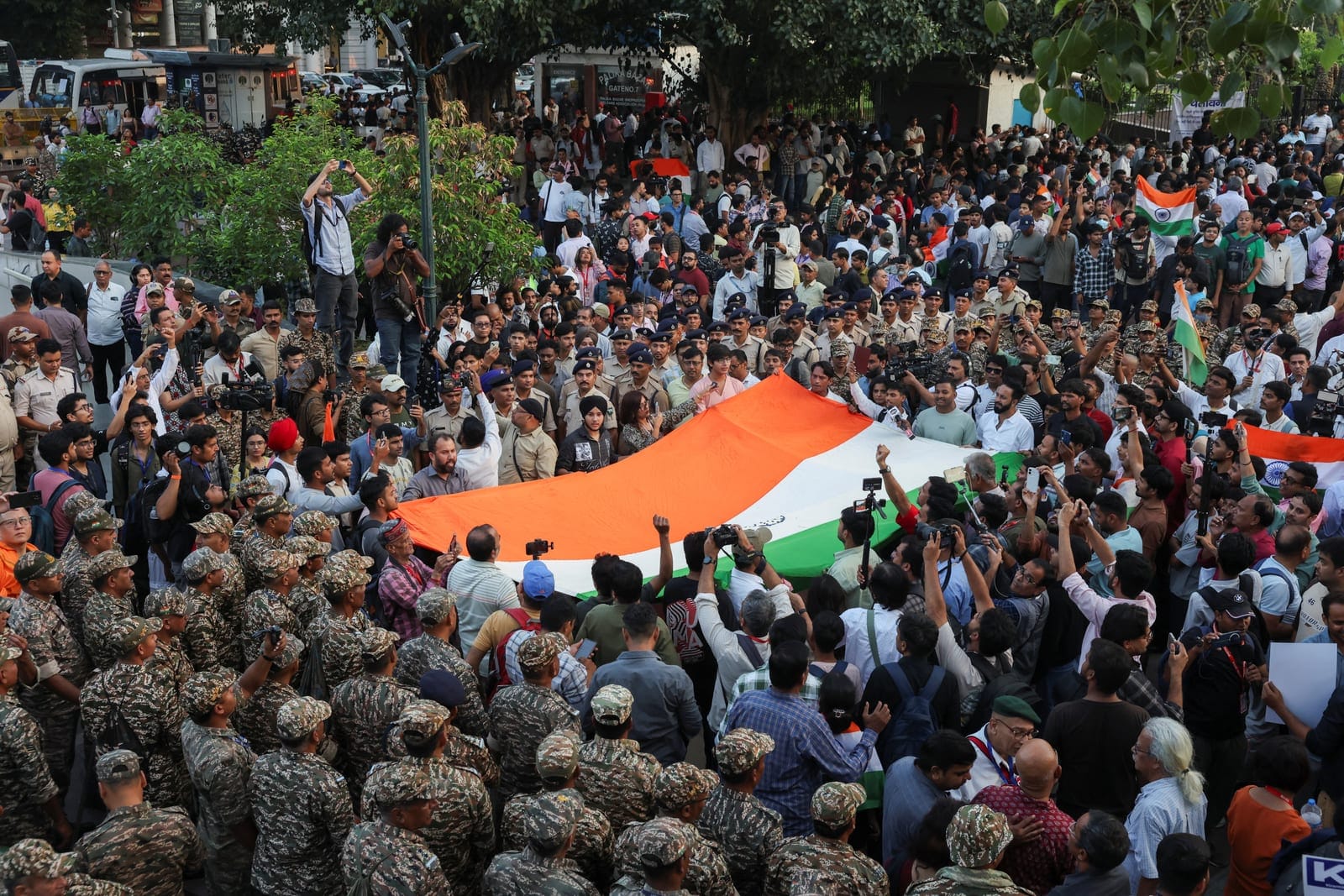 Protestors amid security personnels chant slogans as they take part in a flag rally by the Cockroach Janta Party (CJP) seeking the resignation of India's Chief Election Commissioner Gyanesh Kumar, in New Delhi, India, October 16, 2026. REUTERS/Bhawik