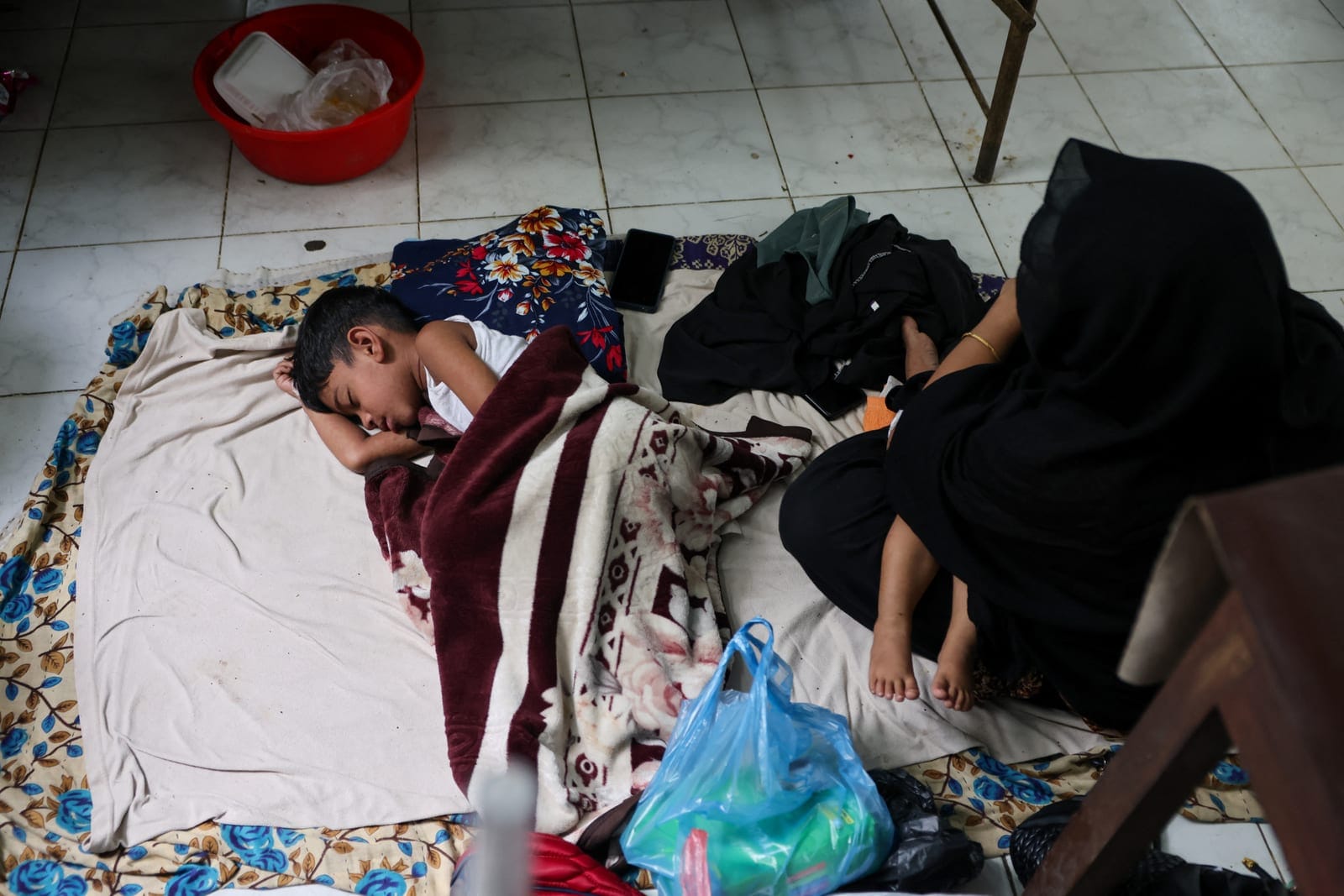 Abu Afwan, 5, who is infected with measles, lies on the floor next to his mother, Ema Begum, 23, while receiving treatment at the overcrowded measles isolation ward of Shahid Shamsuddin Ahmed Hospital in Sylhet, Bangladesh, September 12, 2026. REUTER