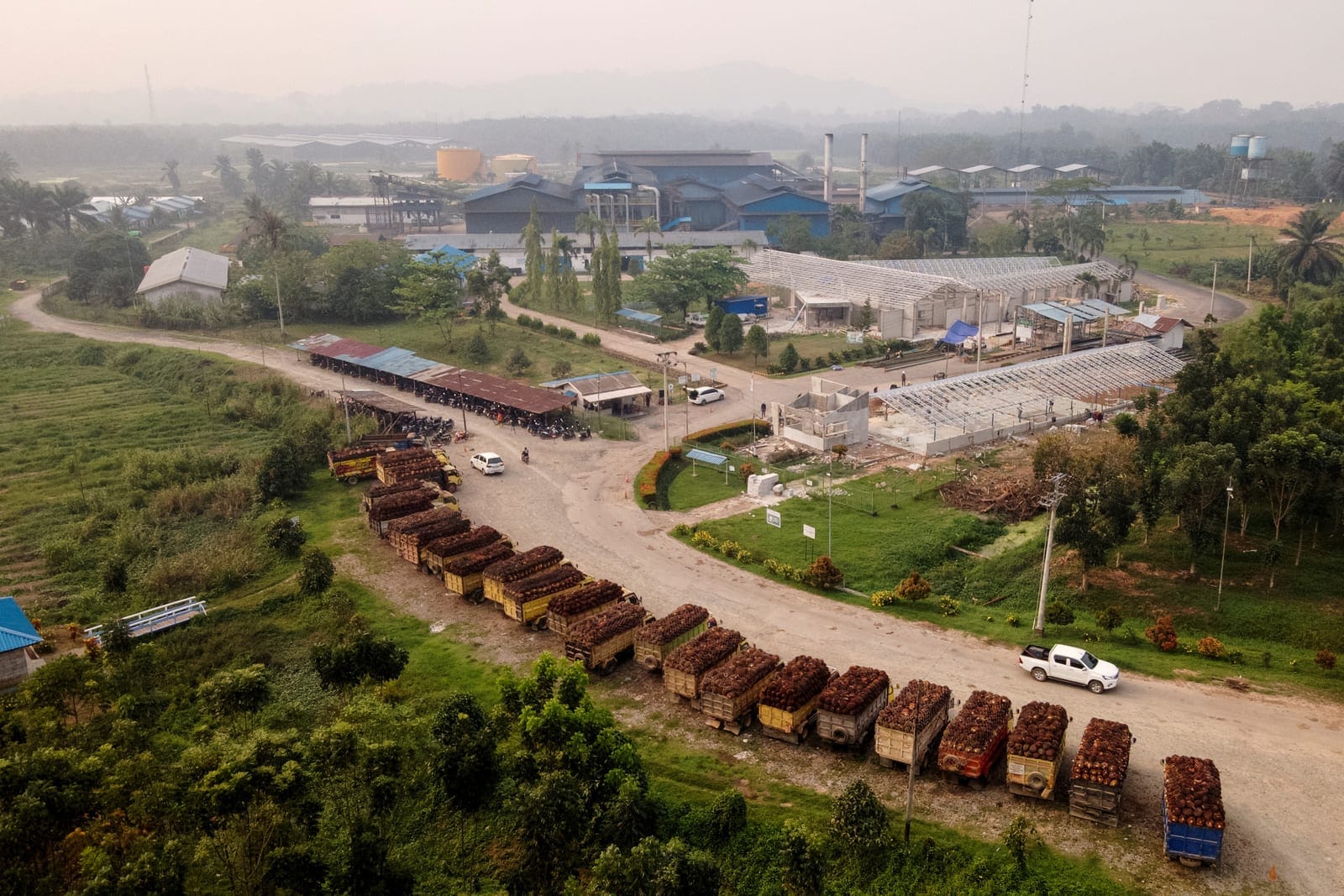 A drone view shows trucks loaded with oil palm fruit bunches waiting outside the Multi Prima Entakai (MPE) palm oil mill in Sanggau, West Kalimantan province, Indonesia, October 2, 2026. REUTERS/Soepriyadi Gunawan