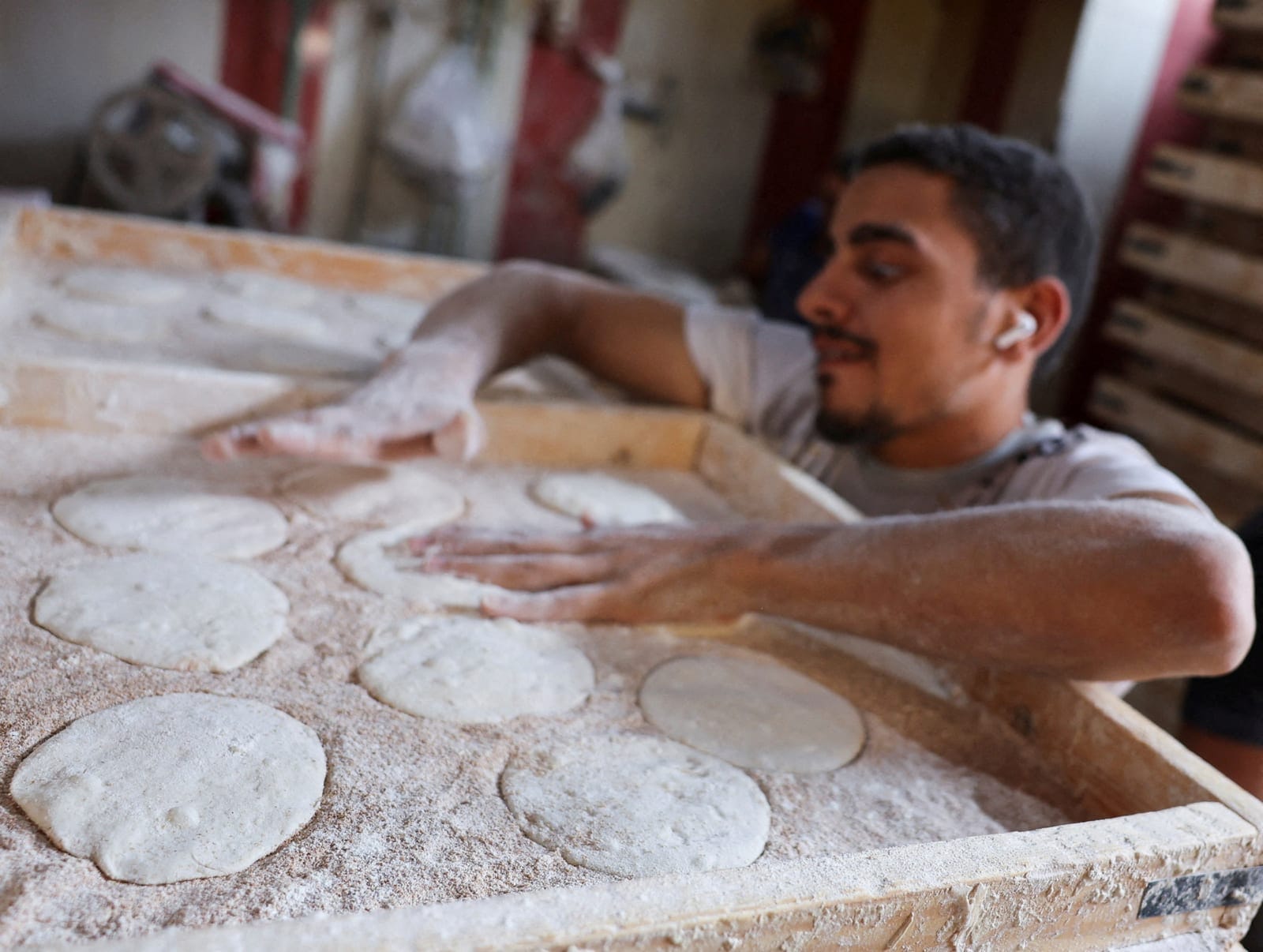 A worker dusts dough with flour before baking traditional Egyptian bread loaves at a bakery, as disruptions to Black Sea grain exports and Red Sea shipping routes increase costs for wheat importers, in downtown Cairo, Egypt, October 13, 2026. REUTERS