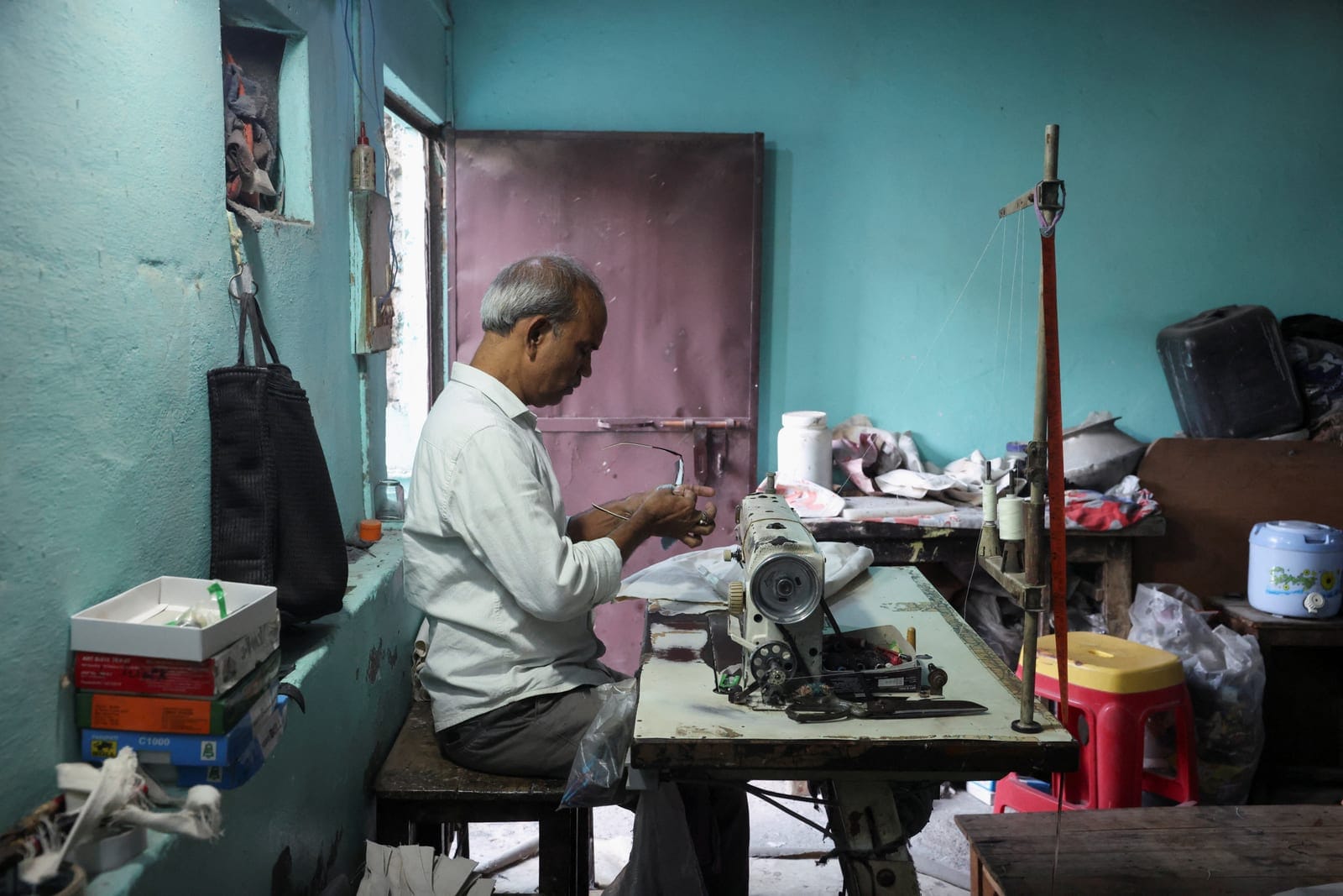 Kamta Prasad, 53, a voter who is listed as "Kanta Prasad" and is declared dead in the Special Intensive Revision (SIR) list published on August 1, 2026, cleans his glasses at his workstation, in New Delhi, India, October 19, 2026. REUTERS/Priyanshu S