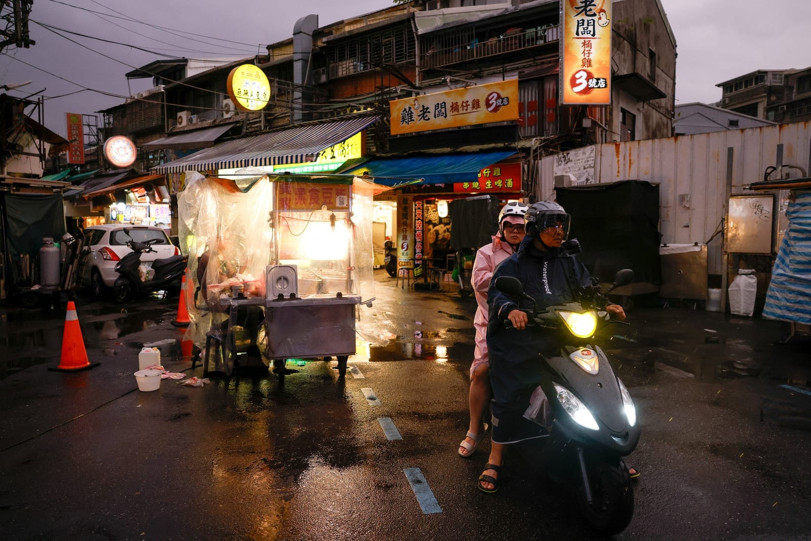 People ride a scooter along a wet street as Typhoon Champi approaches, in Taipei, Taiwan, October 22, 2026. REUTERS/Ann Wang