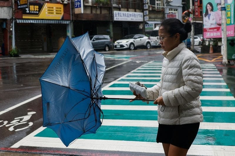 A pedestrian holds an umbrella in strong winds as Typhoon Champi approaches Taiwan, in Keelung, Taiwan, October 23, 2026. REUTERS/Ann Wang