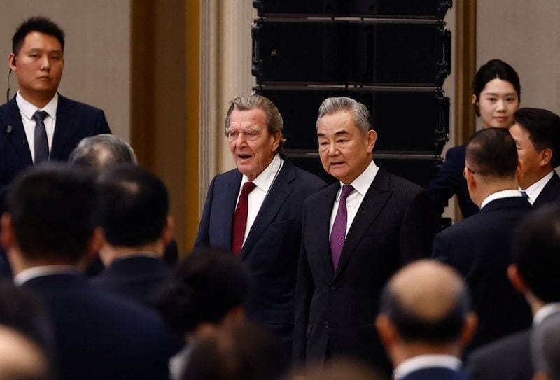 Chinese Foreign Minister Wang Yi and former German Chancellor Gerhard Schroeder enter the hall before the opening ceremony for the inaugural Global Governance Forum in Xiongan New Area, Hebei province, China, October 23, 2026. REUTERS/Maxim Shemetov