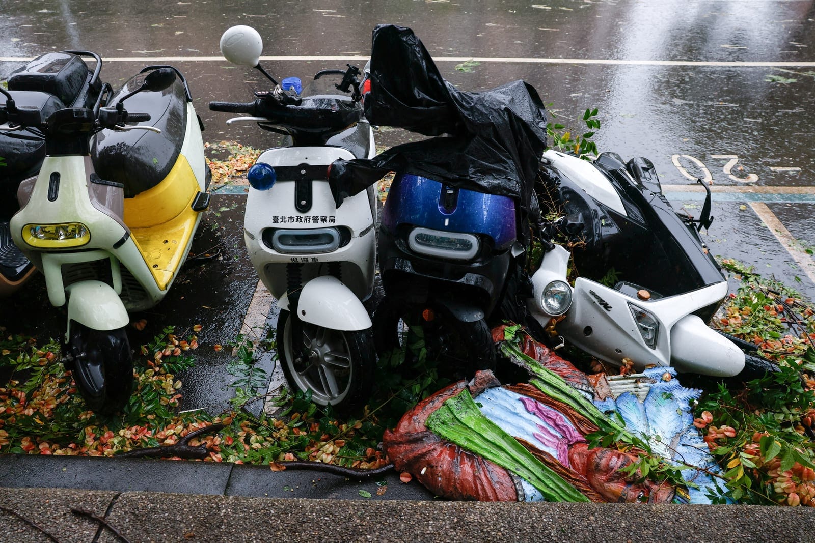 Scooters damaged by fallen debris lie on the side of a road after strong winds brought by Typhoon Champi, in Taipei, Taiwan October 24, 2026. REUTERS/Ann Wang