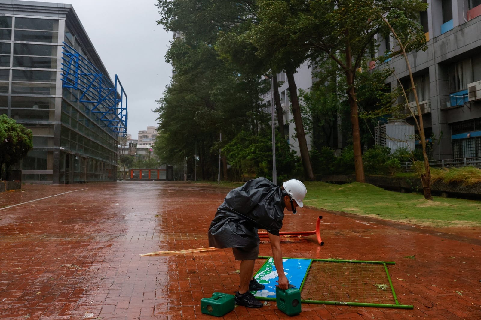 A worker secures a sign as Typhoon Champi approaches Taiwan, in Taipei, Taiwan, October 23, 2026. REUTERS/Ann Wang