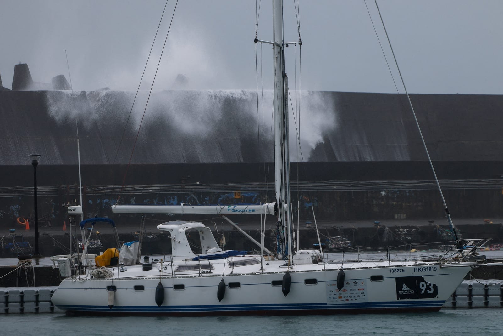 A sailboat is moored near a breakwater as waves generated by Typhoon Champi hit Badouzi Fishing Port in Keelung, Taiwan, October 23, 2026. REUTERS/Ann Wang