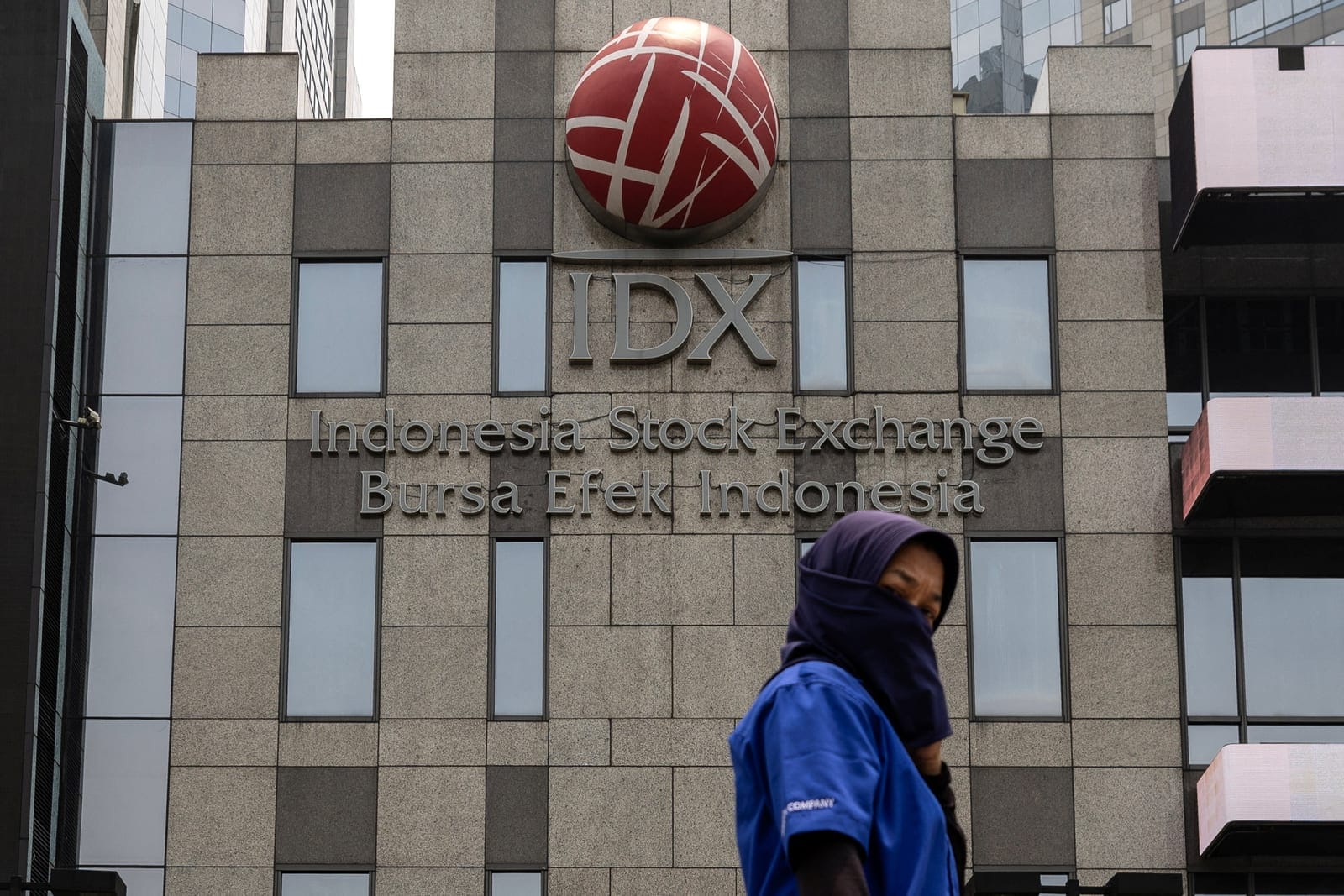 A woman covering her face walks past the Indonesia Stock Exchange (IDX) building in Jakarta, Indonesia, October 21, 2026. REUTERS/Willy Kurniawan