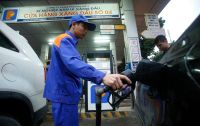 A attendant pumps petrol for a car at a petrol station in Hanoi