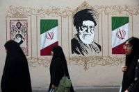 FILE PHOTO: People walk by a mural depicting Iran's late Supreme Leader Ayatollah Ali Khamenei in Tehran