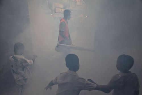 A man fumigates a road as a preventive measure against mosquito-borne diseases, particularly dengue, in Dhaka