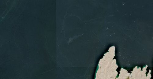 A satellite image shows containers and items floating in the water after a vessel sank near the Strait of Hormuz, off the coast of Oman