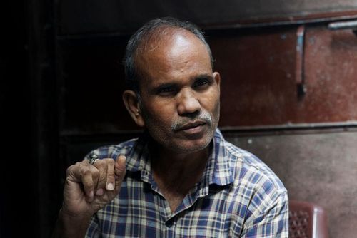 Kamta Prasad, a voter who is listed as "Kanta Prasad" and is declared dead in the SIR list, gets ready before leaving for work, in New Delhi