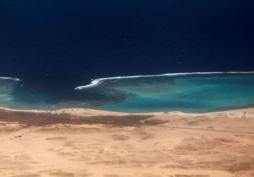 An aerial view shows the coast of the Red Sea, through the window of a plane before landing, in Marsa Alam
