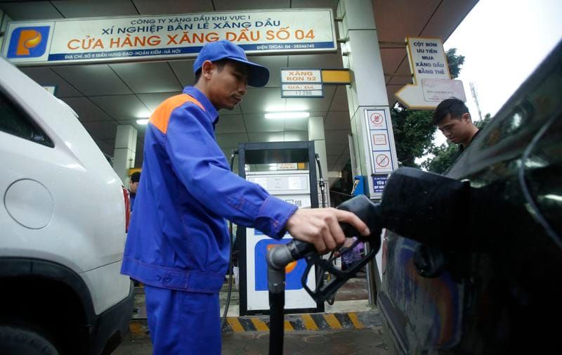 A attendant pumps petrol for a car at a petrol station in Hanoi