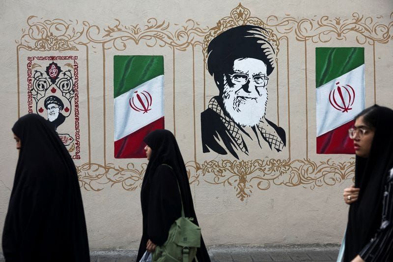 FILE PHOTO: People walk by a mural depicting Iran's late Supreme Leader Ayatollah Ali Khamenei in Tehran