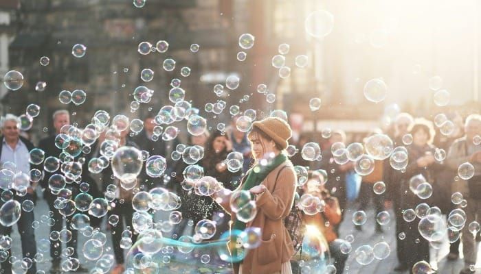 Woman in a city with scattered soap bubbles