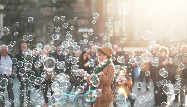 Woman in a city with scattered soap bubbles