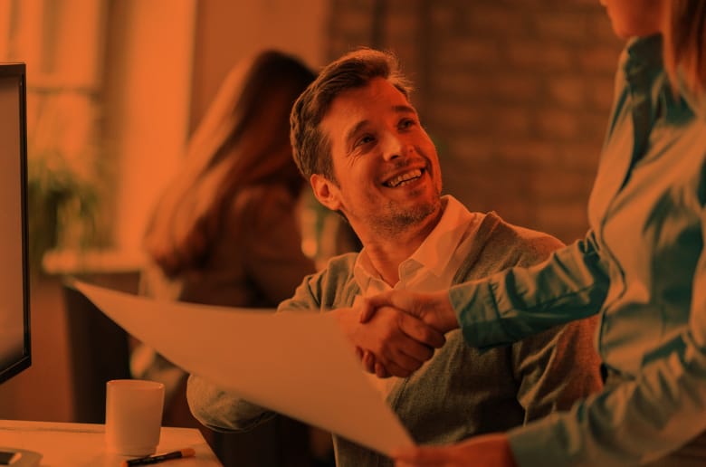 Two coworkers shaking hands. 