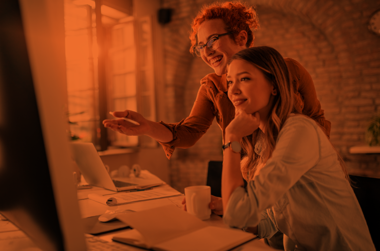 Colleagues collaborating at a computer in the workplace, supporting teamwork and career advancement