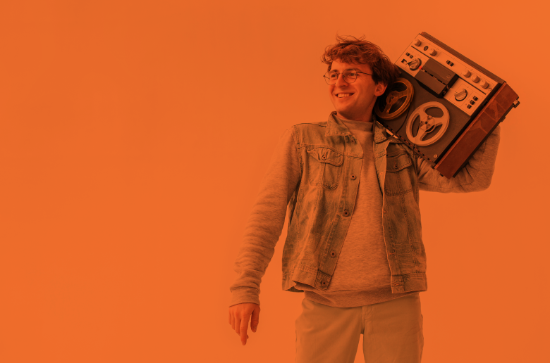 Young man holding a radio smiling.