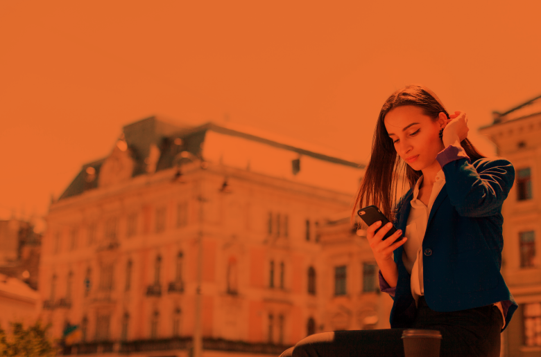 Woman in a European capital sitting and scrolling on phone. 