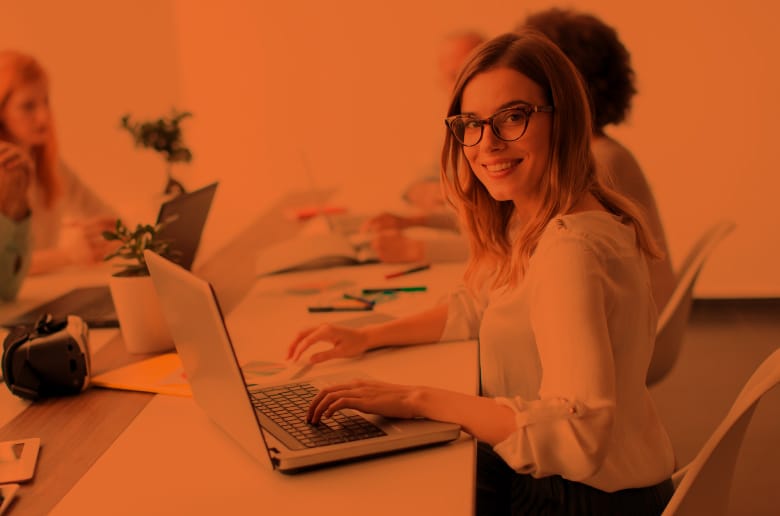 Professional woman smiling while typing on her laptop. 