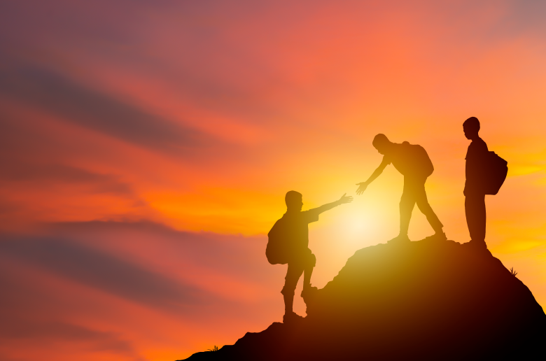 People climbing on a hill and helping each other