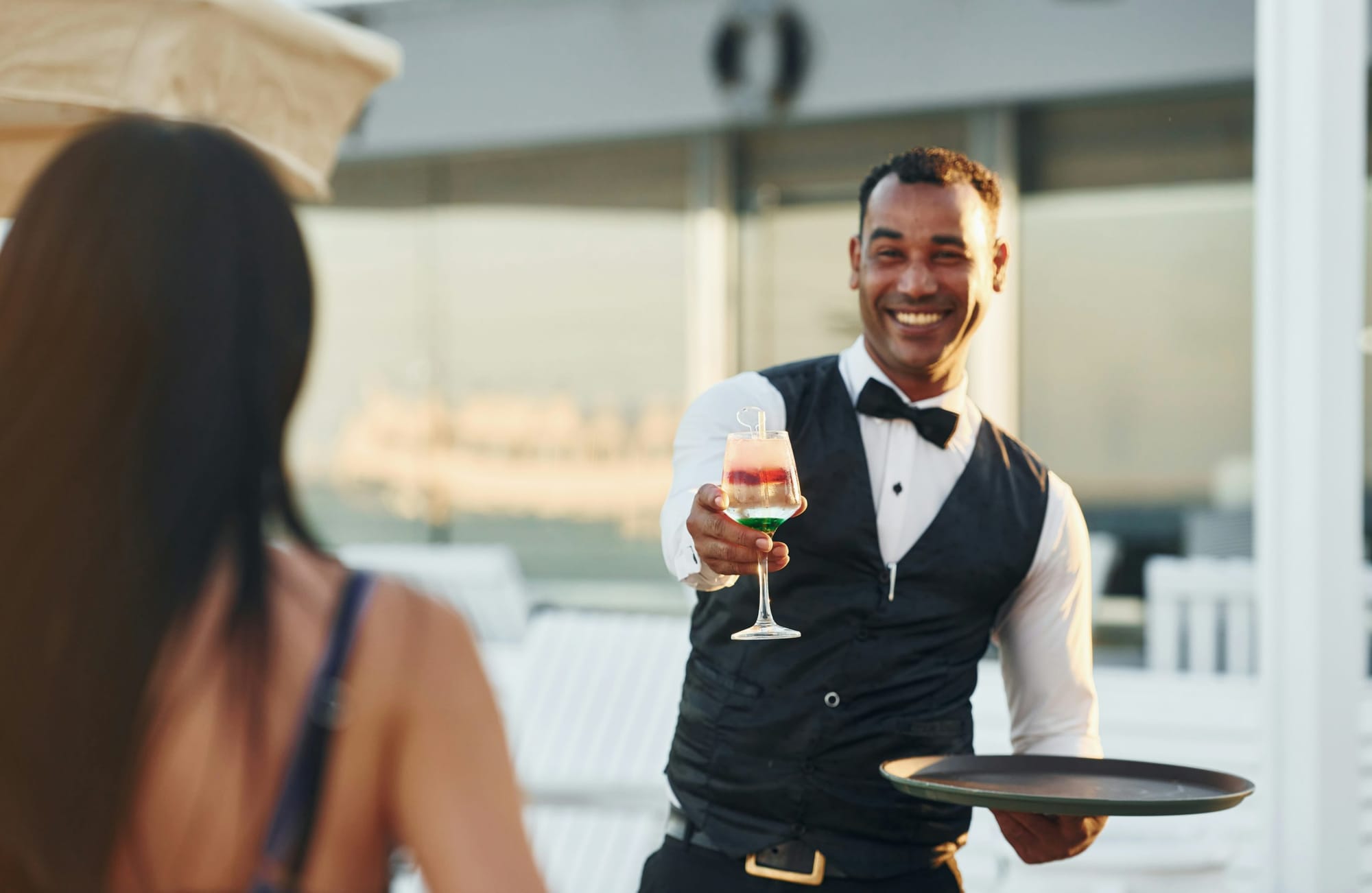 Waiter offering a drink to a guest.