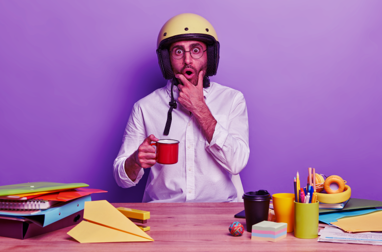 Employee holding coffee mug sitting in office. 