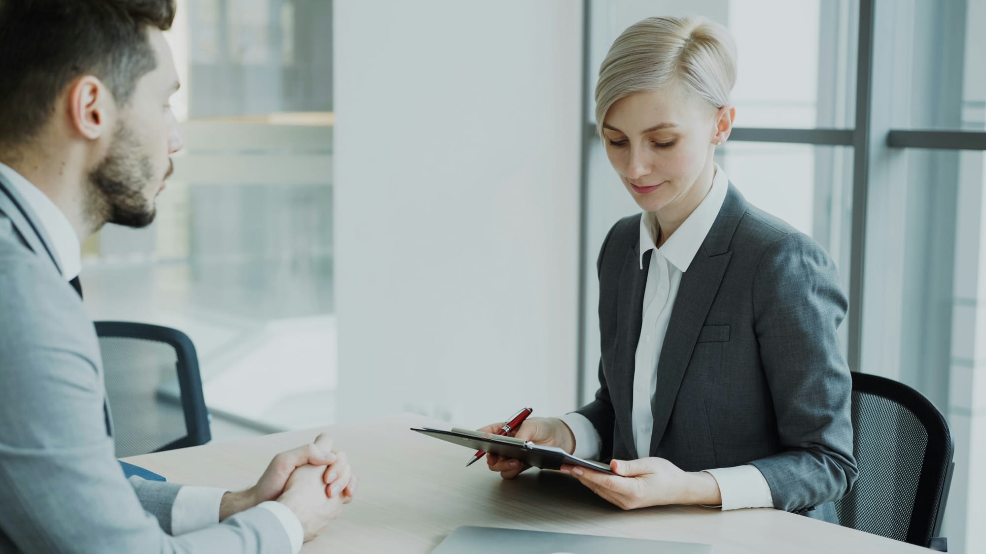 Professional man having an interview with a professional woman sitting across each other.