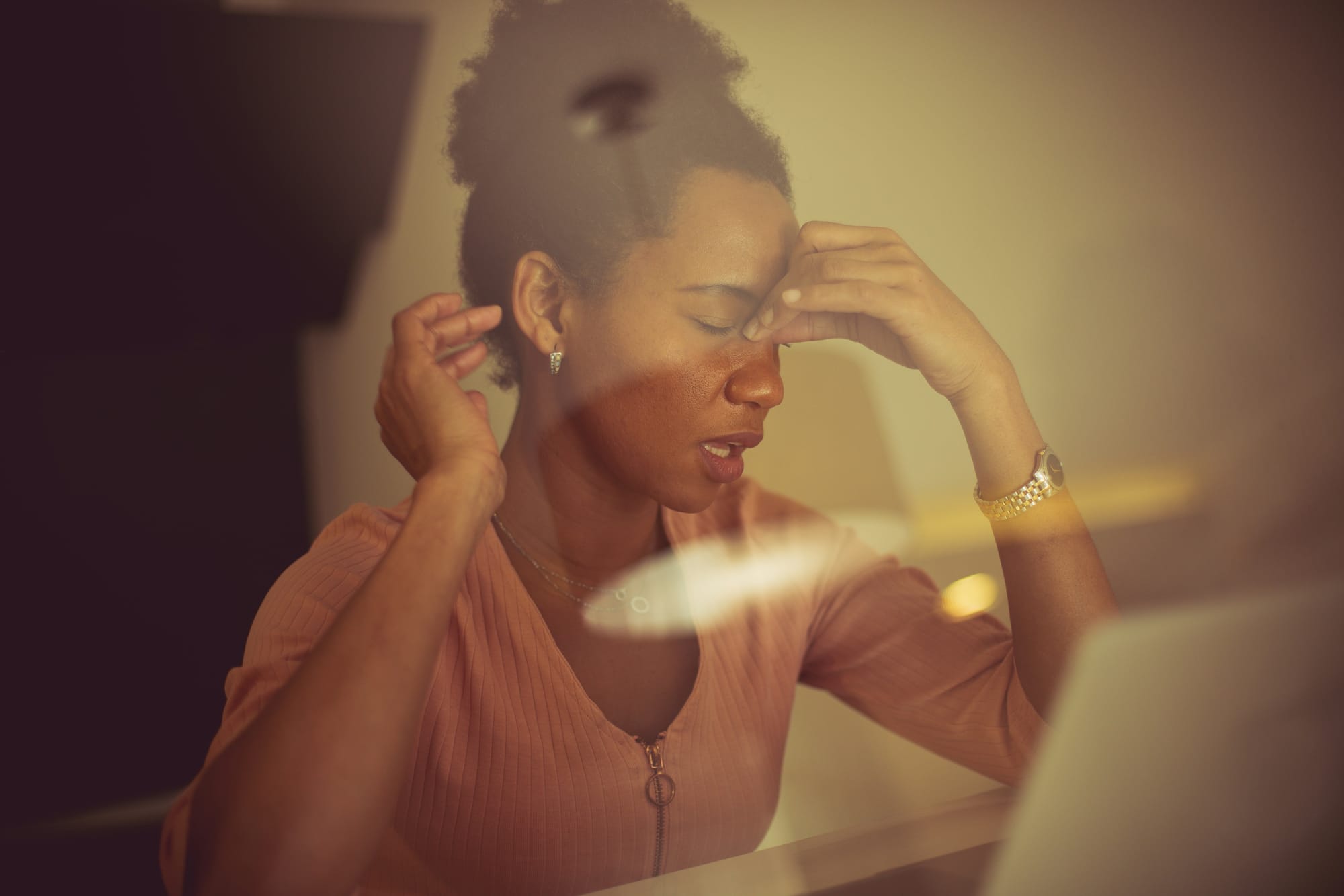 Employee feeling stressed while working on a laptop, illustrating poor work-life balance.