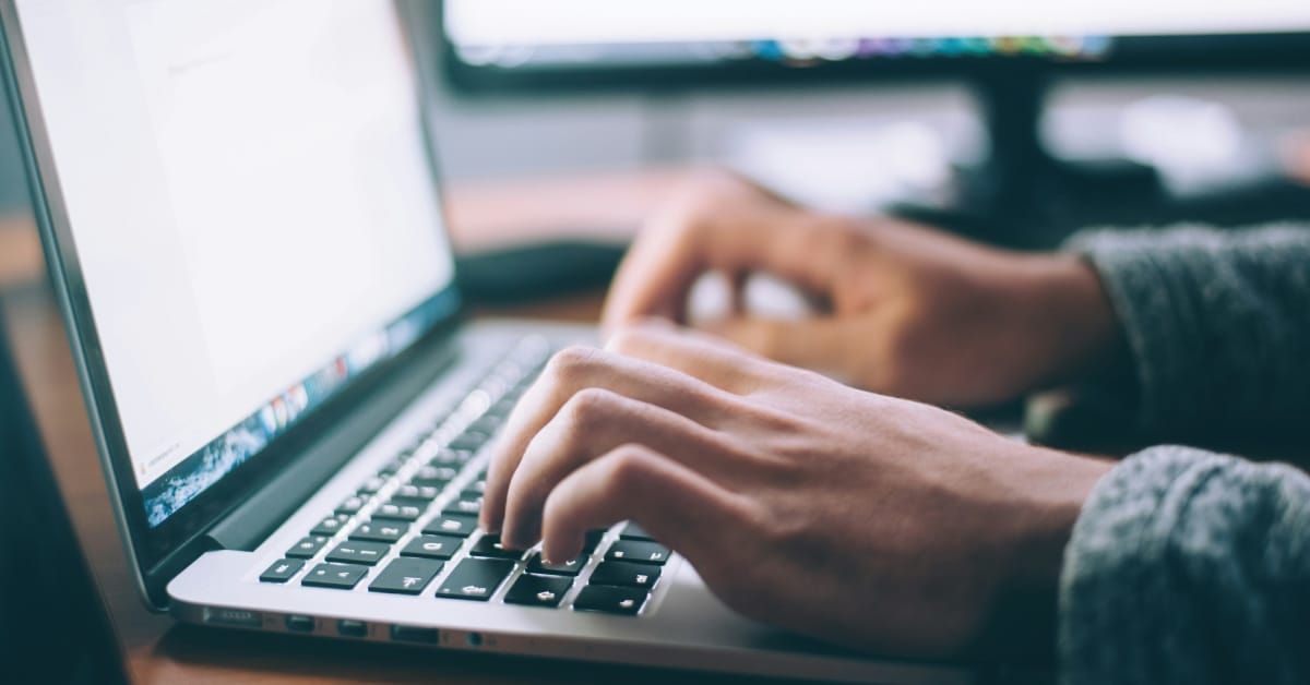 Person typing on a laptop. 