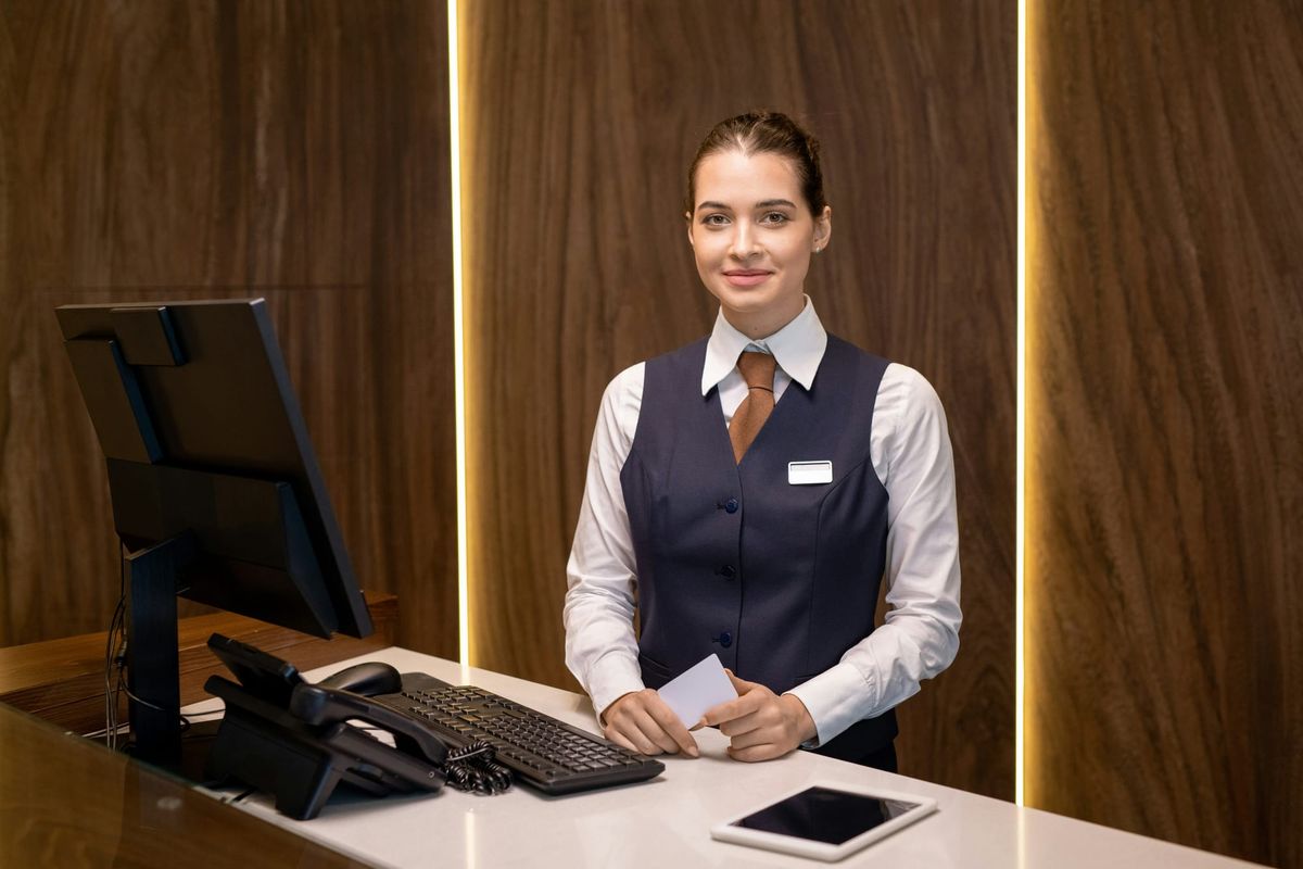 Hotel receptionist at front desk welcoming guests in the hospitality industry