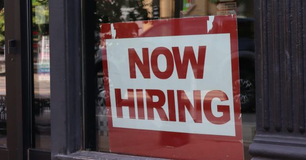 Shop glass with a sign "Hiring Now"