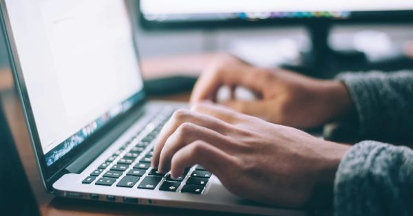 Person typing on a laptop. 