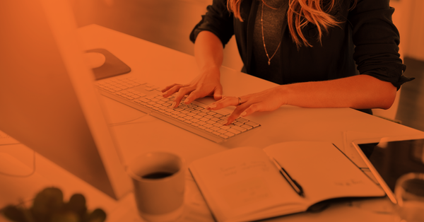 Woman typing on her keyboard while sitting on office desk. 