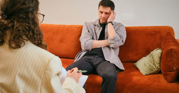 Sad job seeker sitting on a couch discouraged. 