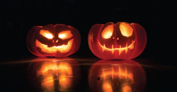Two Halloween pumpkins smiling. 