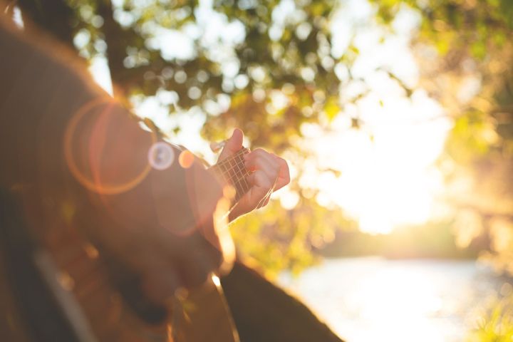 Person playing ukulele outdoors