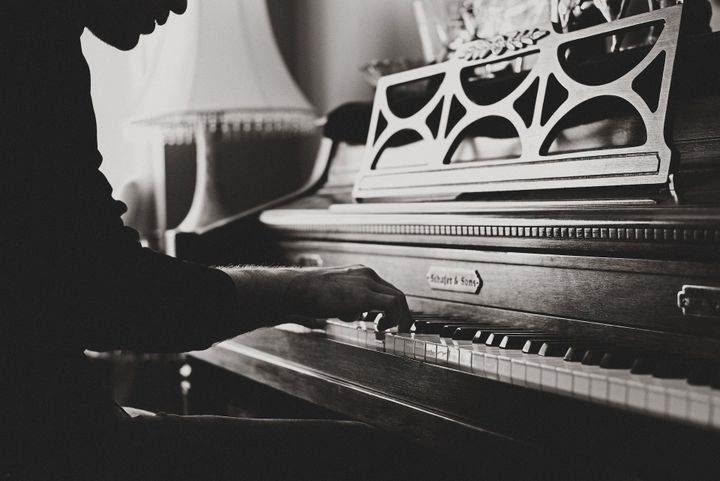 Piano student practicing on an upright piano