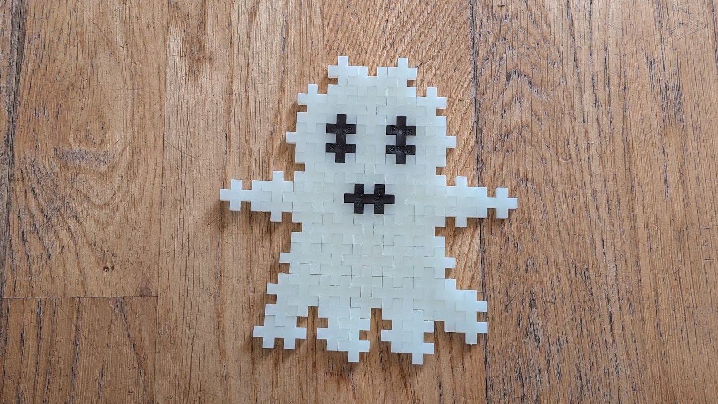 A ghost made from Plus Plus pieces. It's white with black eyes and mouth.