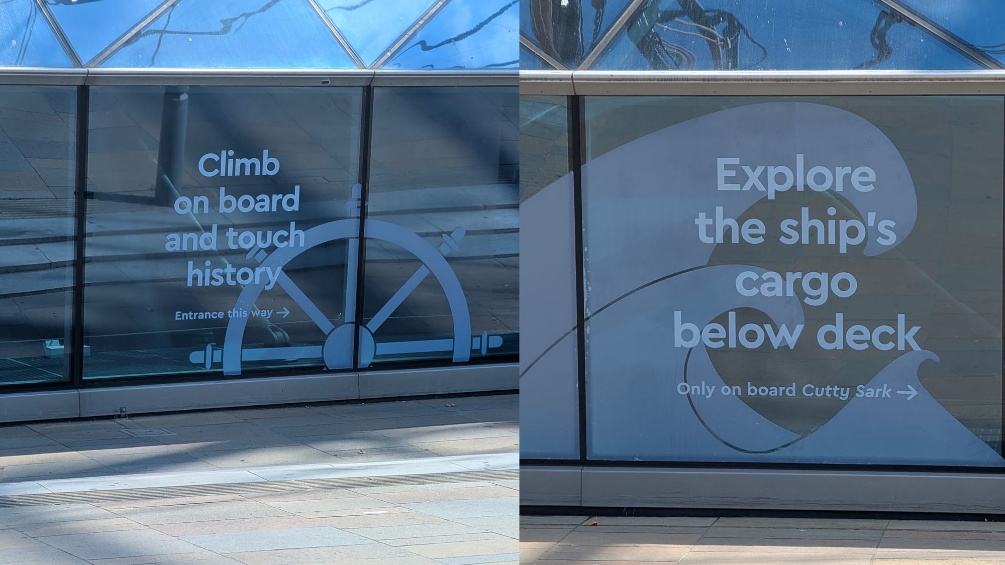Two posters under the Cutty Sark. "Climb on board and touch history," and "Explore the ship's cargo below deck."